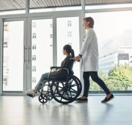 doctor and walking with patient with disability in hospital