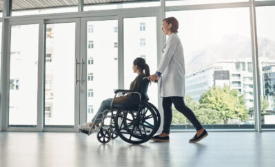 doctor and walking with patient with disability in hospital