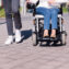 Woman using wheelchair with a man taking a walk