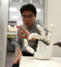A researcher working with a robotic hand