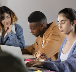 Classmates learning together from laptop and notes