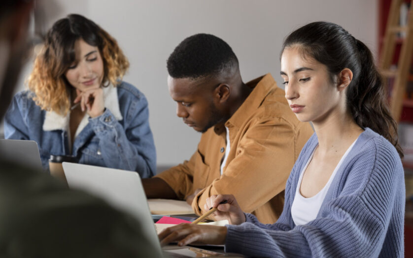 Classmates learning together from laptop and notes
