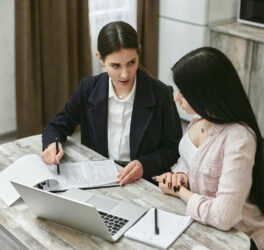 Women Discussing About Paperwork