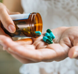 Woman's hand pours the medicine pills out of the bottle