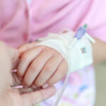 Mother holding child hand in hospital