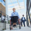 Business woman in a wheelchair in front of the office on a ramp with other workers