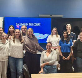 Women standing and sitting around a table after completing a workshop