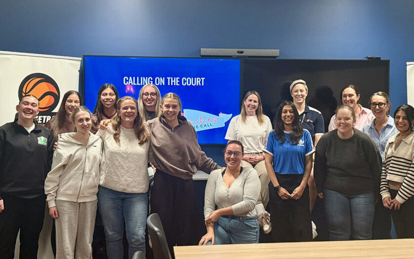 Women standing and sitting around a table after completing a workshop