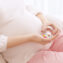 Closeup of pregnant woman holding plastic jar with pills