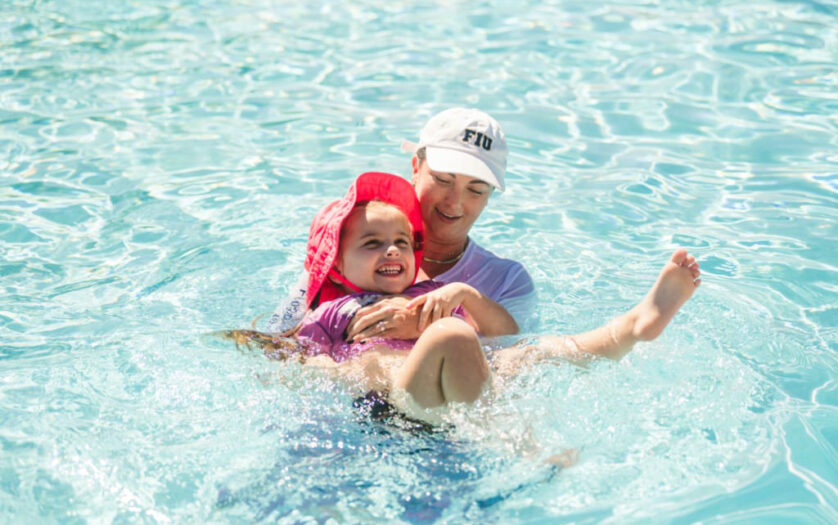 Milaya (left) participates in an adapted swim lesson with Tana Carson (right)
