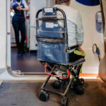 Rear view of man on special wheelchair for transport in the airplane.