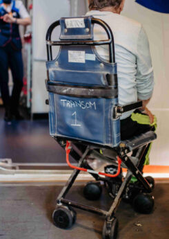 Rear view of man on special wheelchair for transport in the airplane.