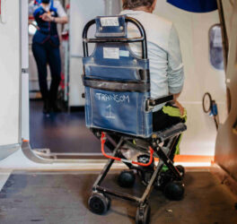 Rear view of man on special wheelchair for transport in the airplane.