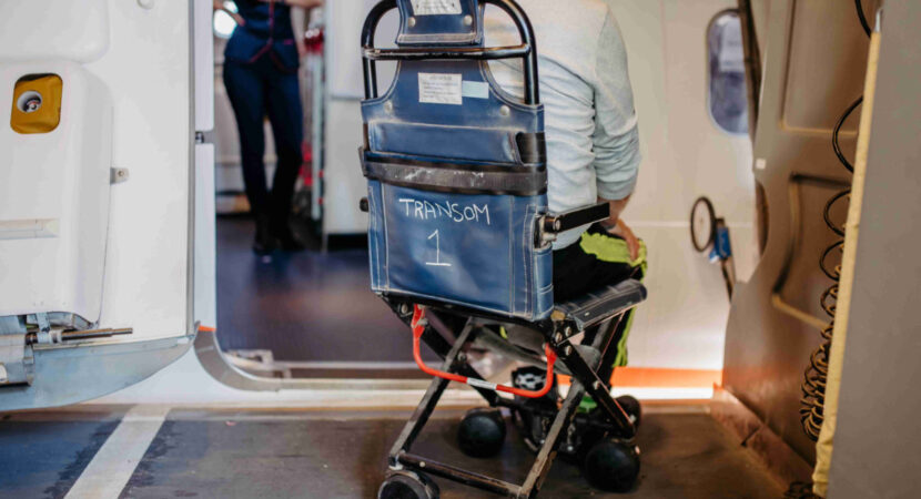 Rear view of man on special wheelchair for transport in the airplane.