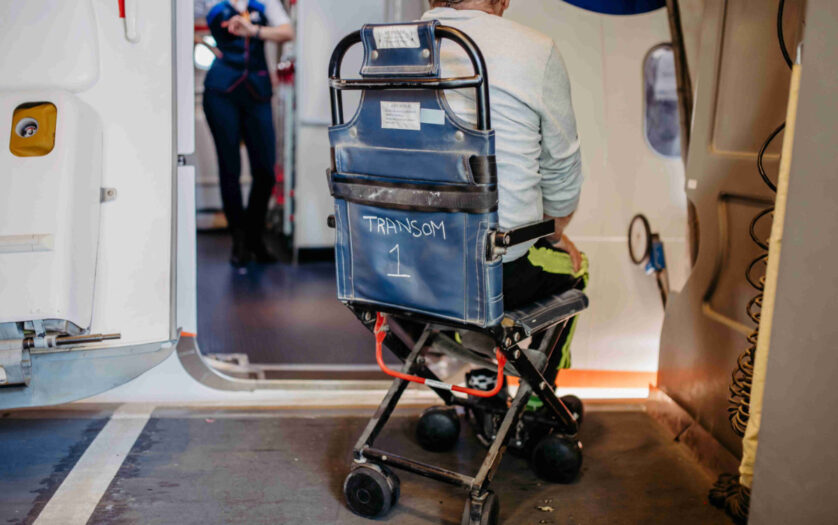 Rear view of man on special wheelchair for transport in the airplane.