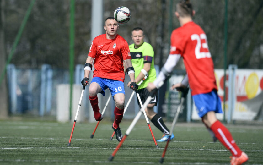 AMP Football Club cup Warsaw Poland 2016, footballers are on a pitch. All have crutches and the ball in the air.