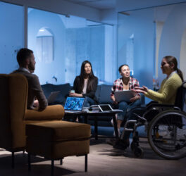 woman in wheelchair with colleagues working in office