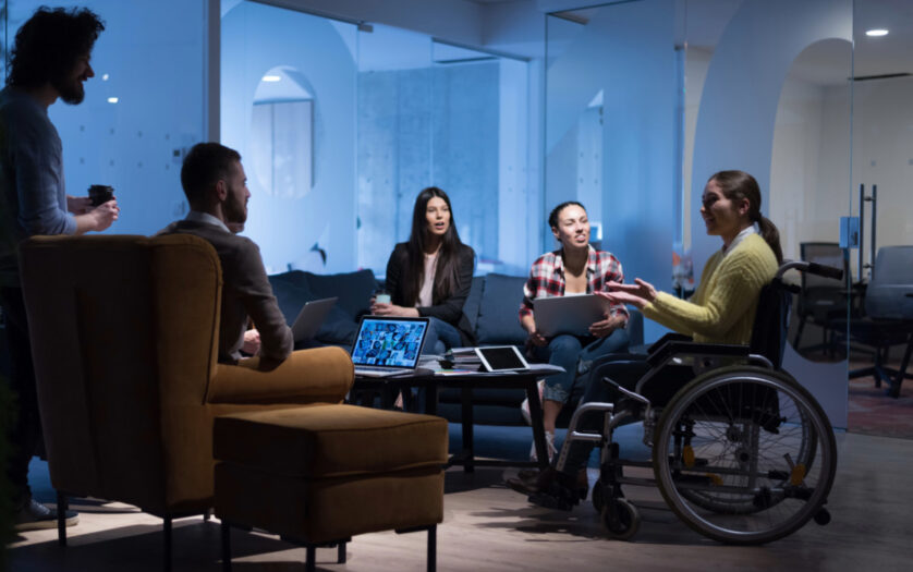 woman in wheelchair with colleagues working in office