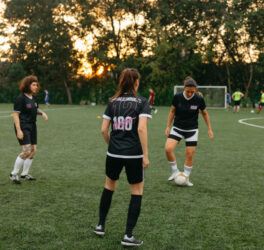 Women soccer players practicing on a field at sunset