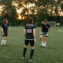 Women soccer players practicing on a field at sunset