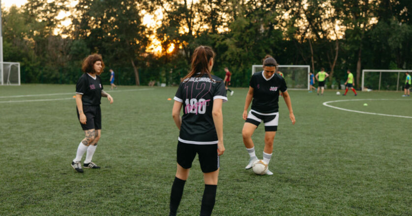 Women soccer players practicing on a field at sunset