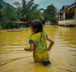 Young girl wades through a flooded area