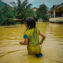 Young girl wades through a flooded area