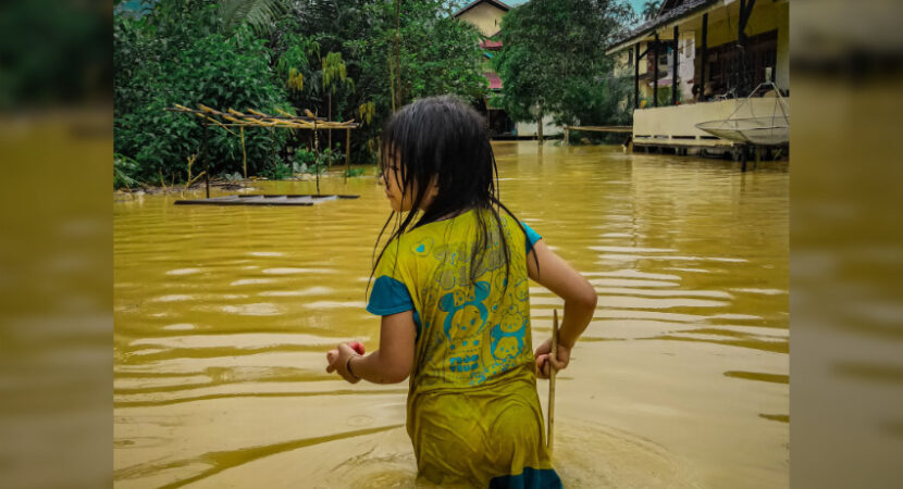 Young girl wades through a flooded area