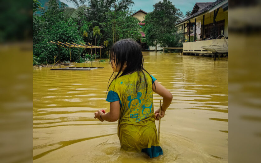 Young girl wades through a flooded area