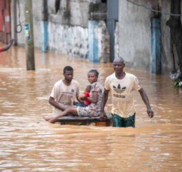 People navigating a flooded street, showcasing resilience amidst natural disaster in Africa.