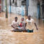 People navigating a flooded street, showcasing resilience amidst natural disaster in Africa.
