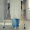 A patient using crutches to walk down a hospital corridor